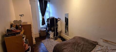 A cozy bedroom with a bed and personal belongin...