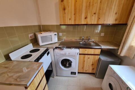 A compact kitchen featuring essential appliance...
