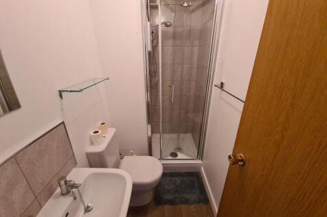 A modern bathroom featuring a compact shower cu...