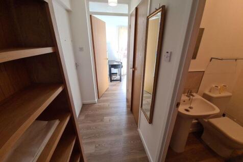 A clean and tidy hallway with light-colored woo...