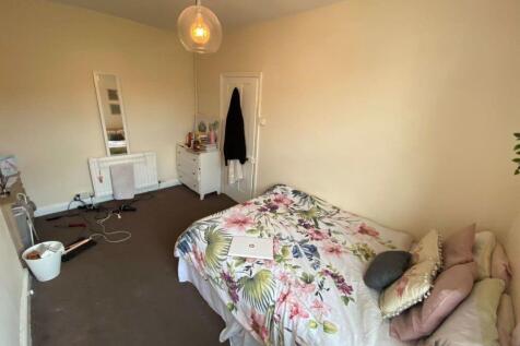 A well-lit, cozy bedroom featuring a double bed...