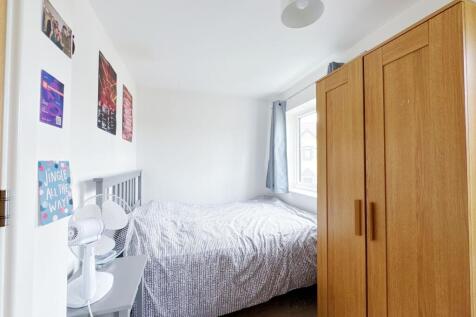 A bright, neatly maintained bedroom featuring a...