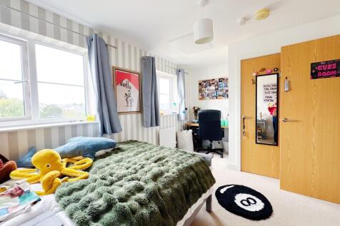 Bright, well-decorated bedroom with large windo...