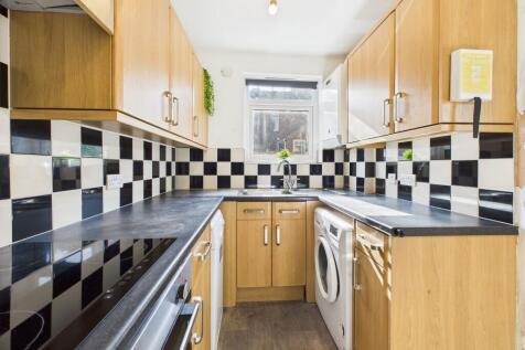Bright and modern kitchen with wooden cabinets,...