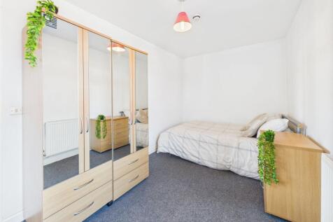 A cozy student bedroom featuring a single bed, ...