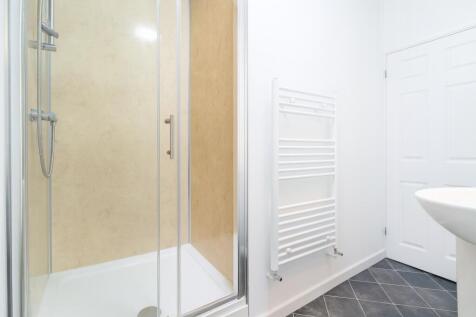 A clean and modern bathroom featuring a shower ...