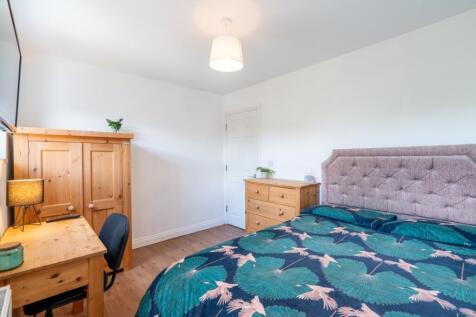 A bright and welcoming double bedroom with a co...