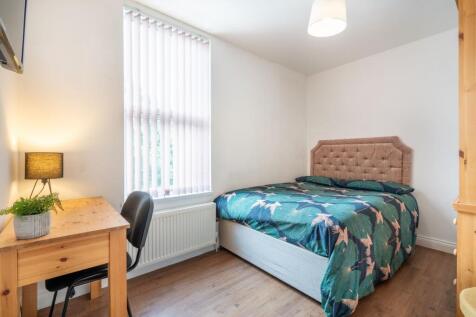 A cozy single bedroom featuring a comfortable b...