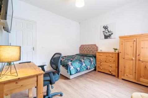 A cozy single bedroom featuring a comfortable b...