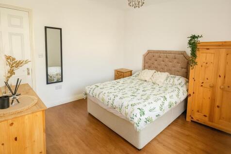 A bright and inviting master bedroom featuring ...