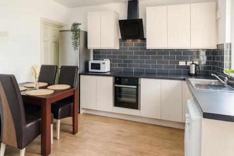 Bright and modern kitchen featuring sleek white...