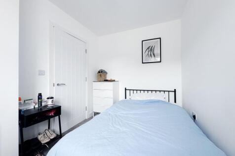 Bright, minimalist single bedroom with crisp wh...