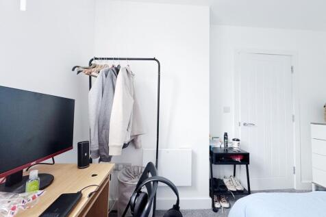 Bright, tidy bedroom with neutral décor featuri...