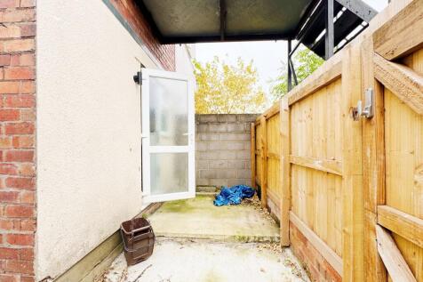 Private paved side yard with a frosted-glass ba...
