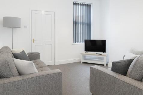 A bright and cozy living room featuring two com...