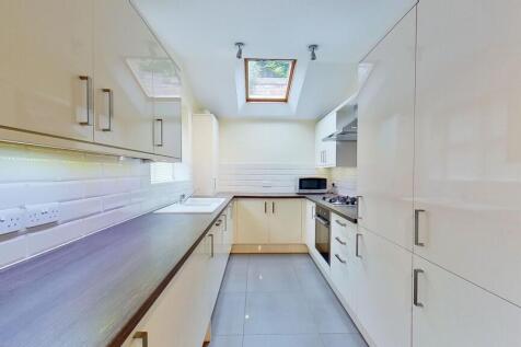 Bright, modern galley kitchen with glossy cream...