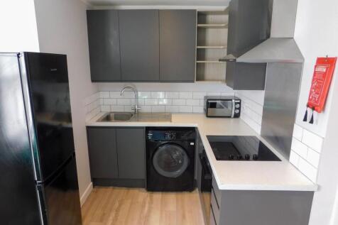 Modern kitchen with sleek gray cabinetry, white...