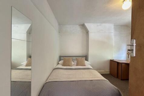 A cozy double bedroom featuring a neatly made b...