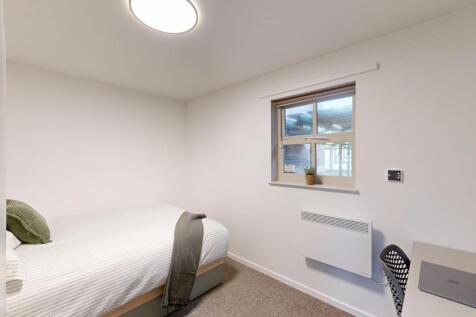 Bright, simply furnished bedroom with neutral d...