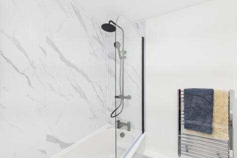 Bright, modern bathroom featuring a sleek showe...