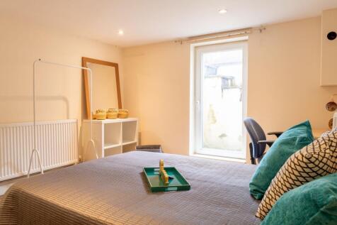 Bright, neatly styled bedroom with a comfortabl...