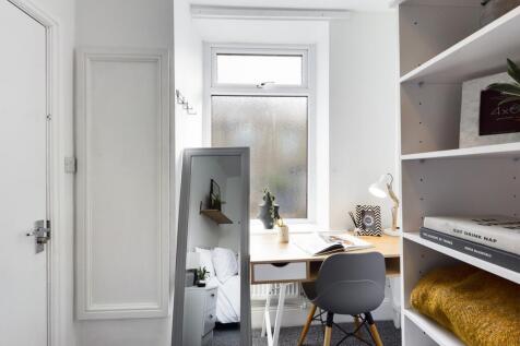 A bright and tidy study area with a desk and mo...
