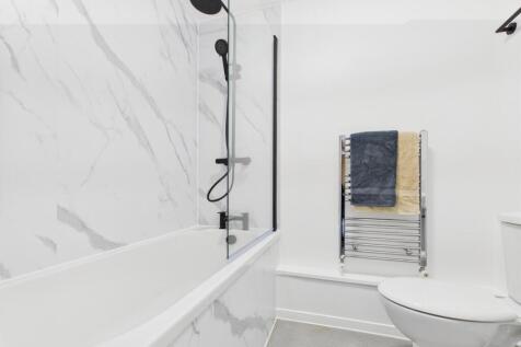 Bright modern bathroom with a bathtub and overh...