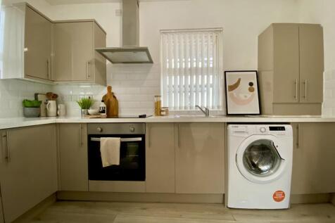 A modern and tidy kitchenette featuring sleek c...