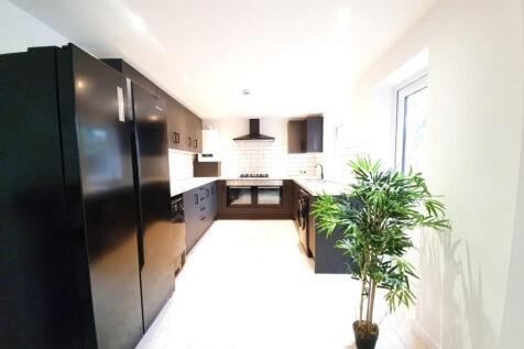 A spacious and modern kitchen featuring sleek b...