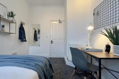 A bright and stylish double bedroom featuring a...
