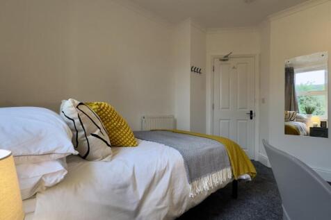 A bright and cozy double bedroom featuring styl...