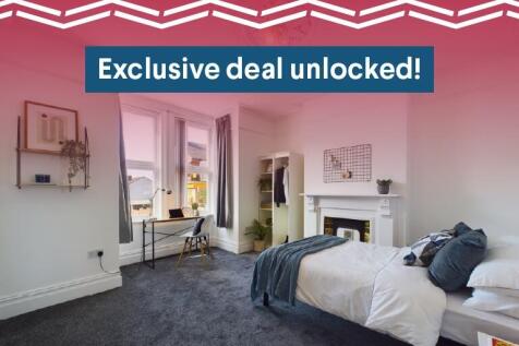 A modern and well-lit bedroom featuring a comfo...