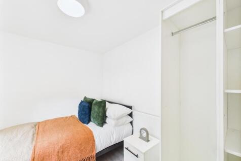 Bright, simply furnished bedroom with a neatly ...