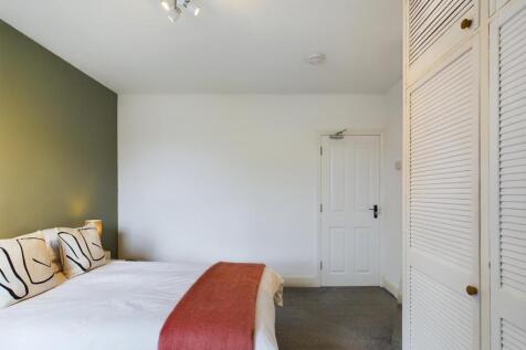A spacious and inviting double bedroom with a m...