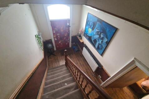 A cozy hallway featuring a carpeted staircase w...