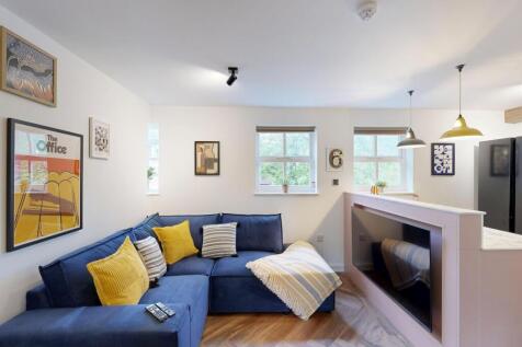 Bright, modern living room with a deep blue L-s...