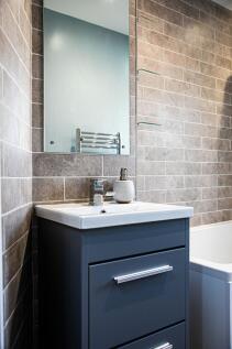 Modern bathroom featuring a sleek dark vanity w...