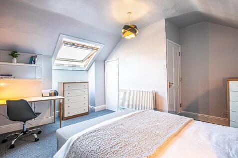 Bright and welcoming bedroom featuring a skylig...