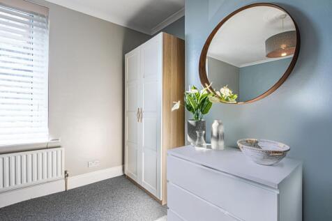 Bright, neatly styled bedroom corner with a mod...