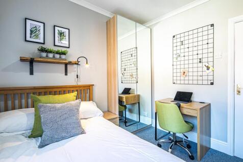 A bright and welcoming bedroom featuring a neat...