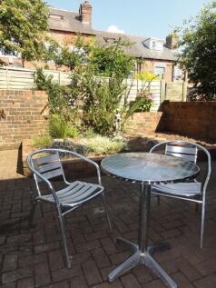 Sunny private paved patio with a metal bistro t...