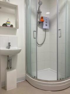 Bright, modern bathroom with a corner shower en...