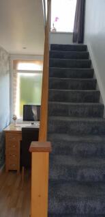 A tidy and well-lit hallway with a workspace, p...