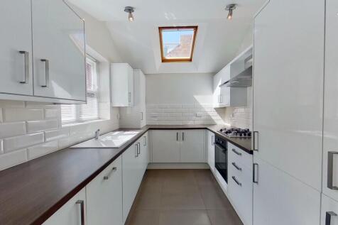 Contemporary galley kitchen with glossy white c...