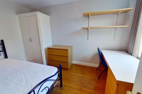 Bright, tidy bedroom with wooden floors, a meta...