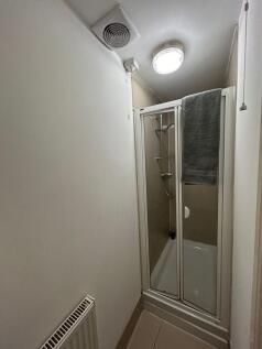 Compact bathroom with a framed glass shower enc...