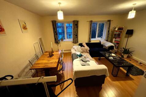 Warm, well-furnished living room with wooden fl...