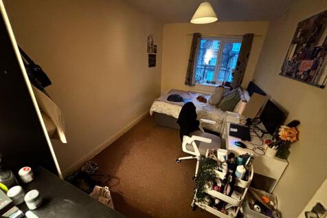 Cozy furnished single bedroom with a bed by the...