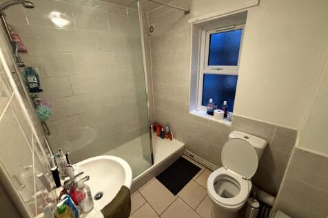Bright, tiled bathroom with a walk-in shower an...