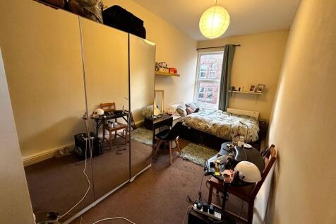 Well-lit double bedroom with a comfy bed by a l...